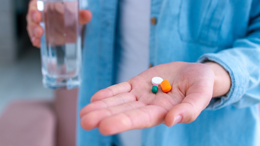 Hand mit Tabletten Hand hält verschieden farbige Tabletten
